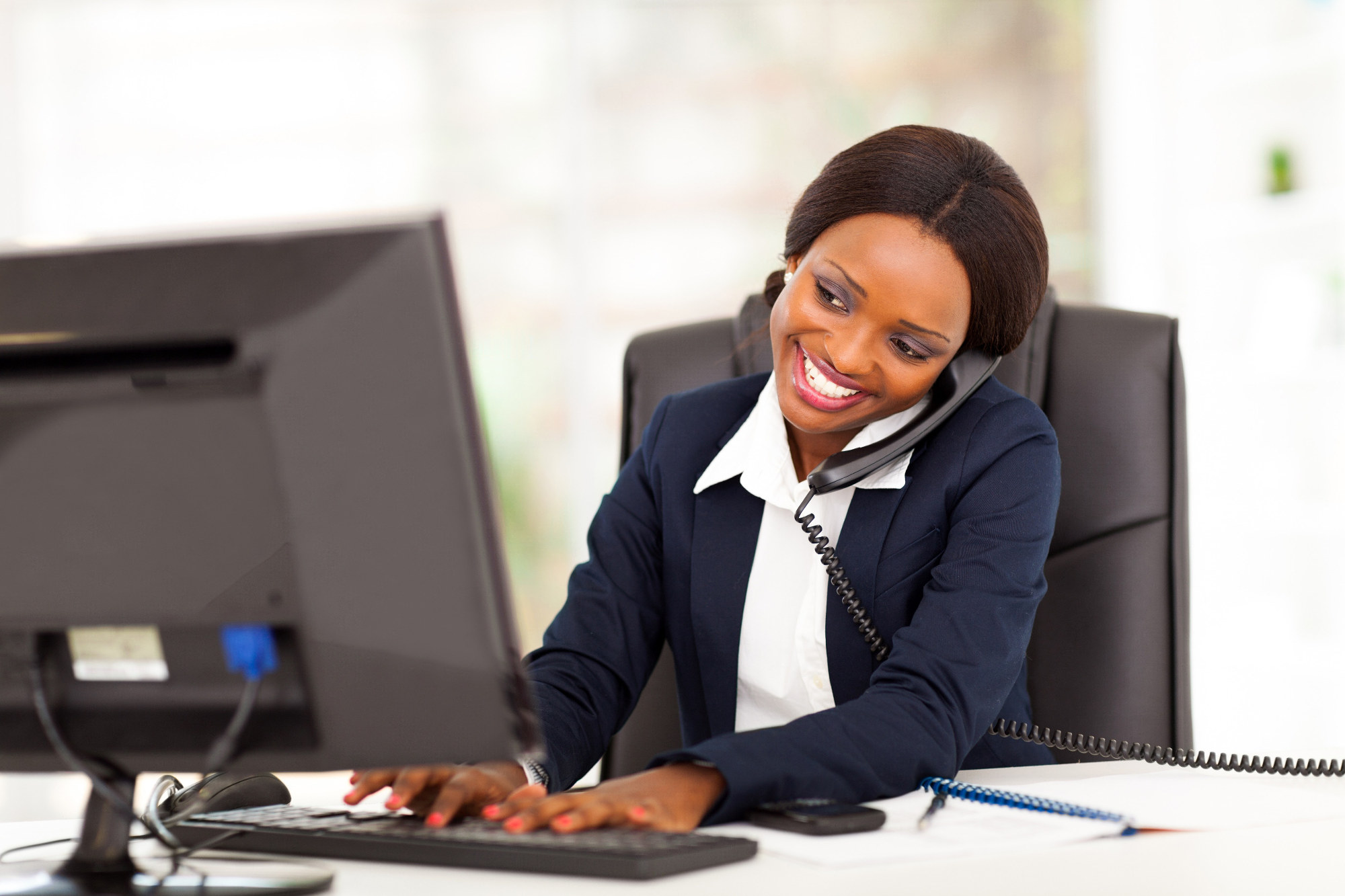 Businesswoman talking on desktop phone in office