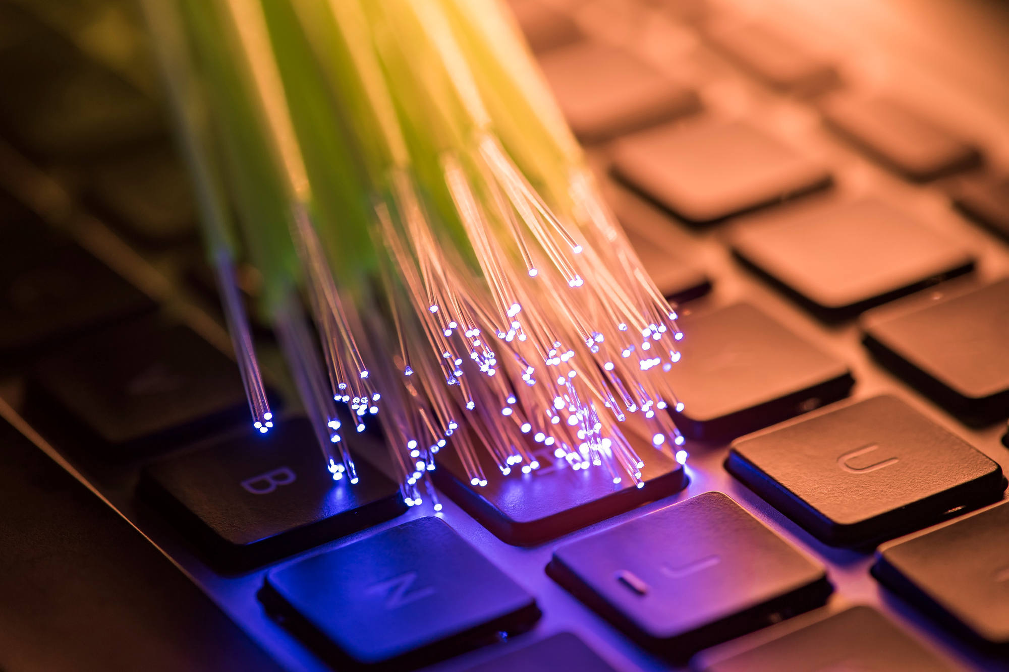 Fiber optic cable against computer keyboard background