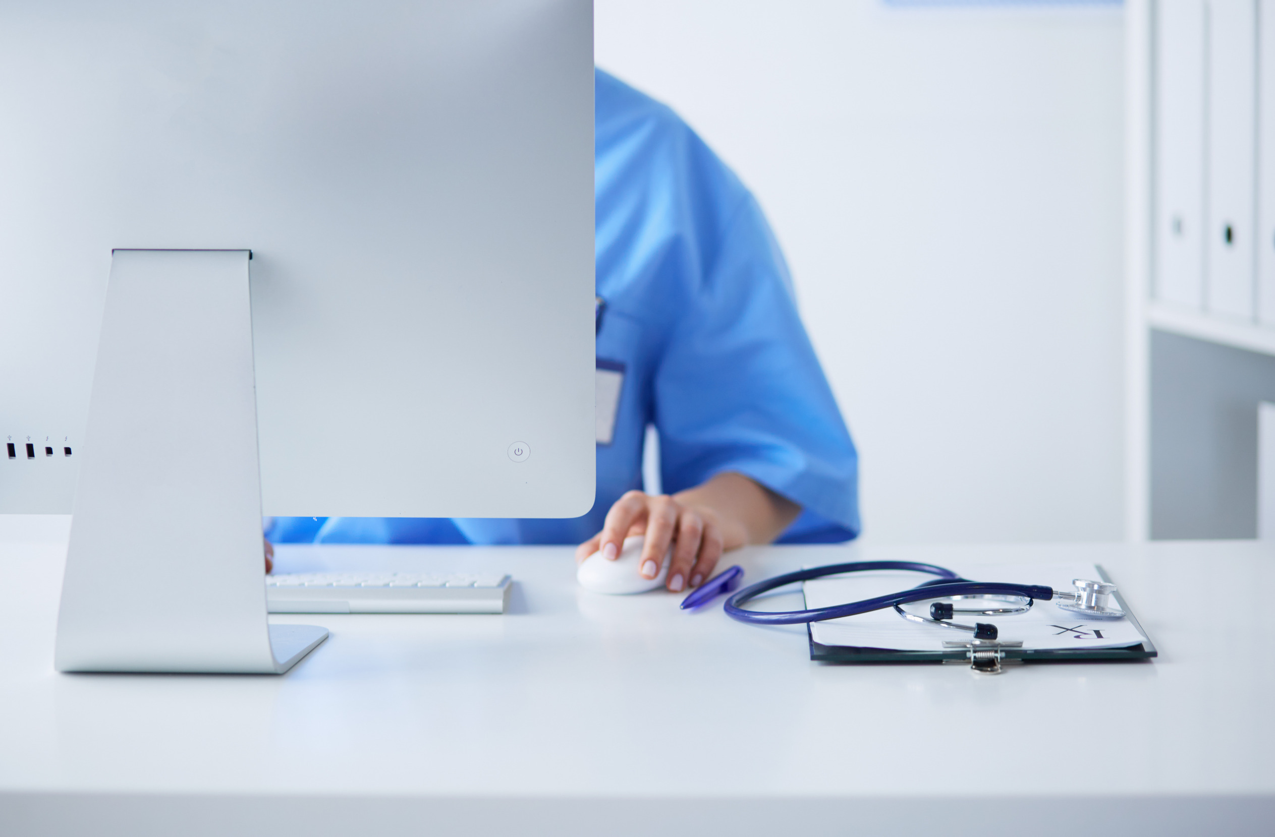 Woman doctor adding information into computer